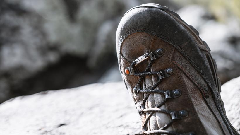 Close-up of a hunter's boot on a rocky cliff