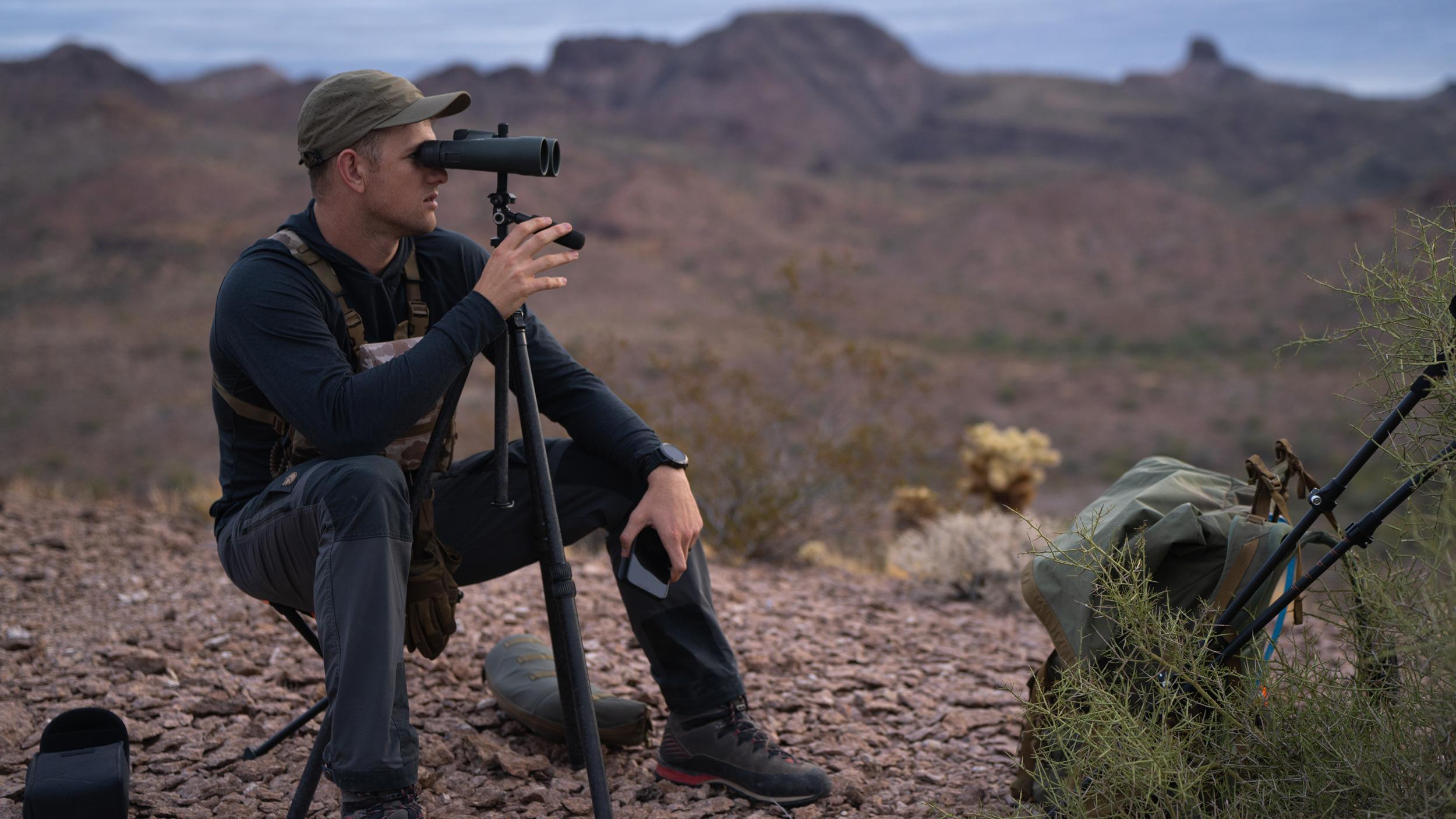 Glassing with binoculars mounted on a tripod in desert mountains