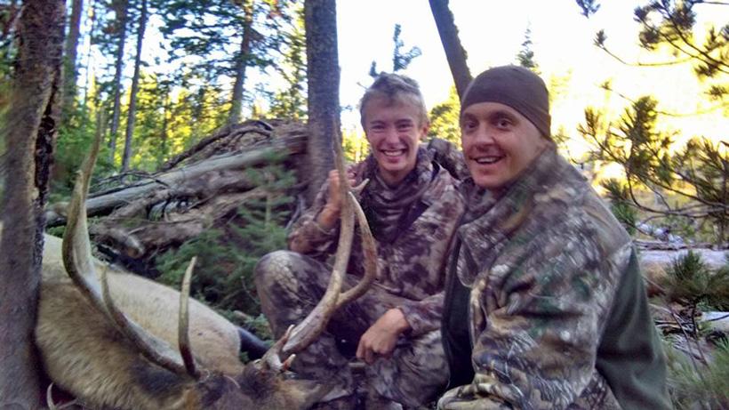 Clint como and his son with a bull elk