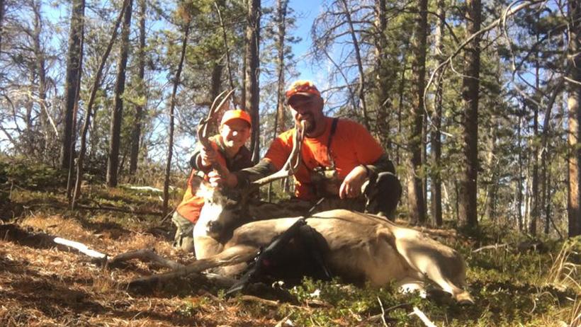 Father and son with a colorado mule deer buck