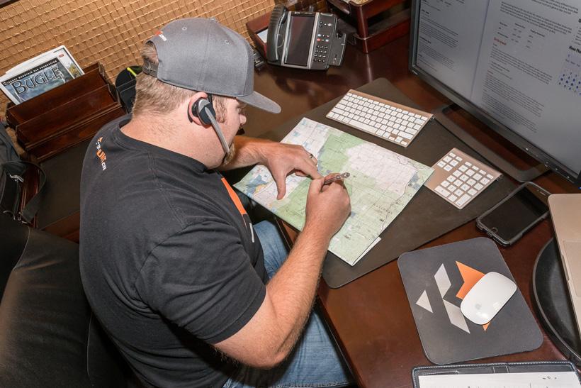 Writing down notes on a map while talking to a biologist