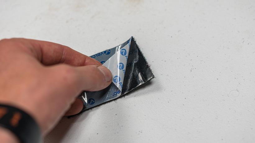 Peeling off backing on velcro tape