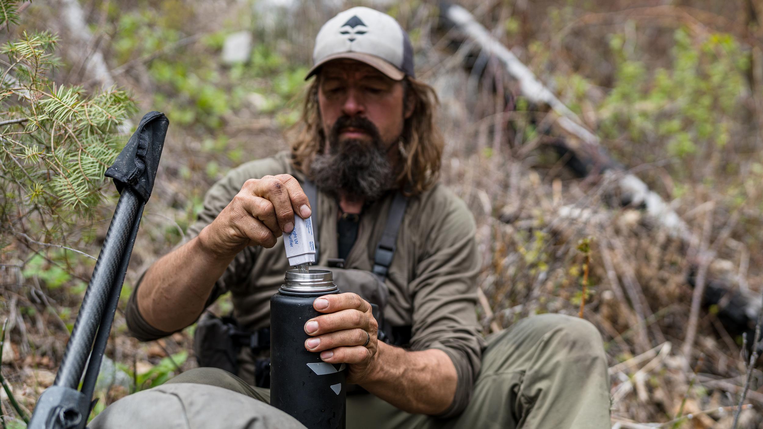 Ryan Lampers filtering water in backcountry with a Steripen