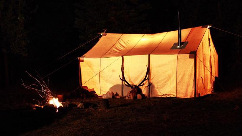 Wall tent at night with elk antlers