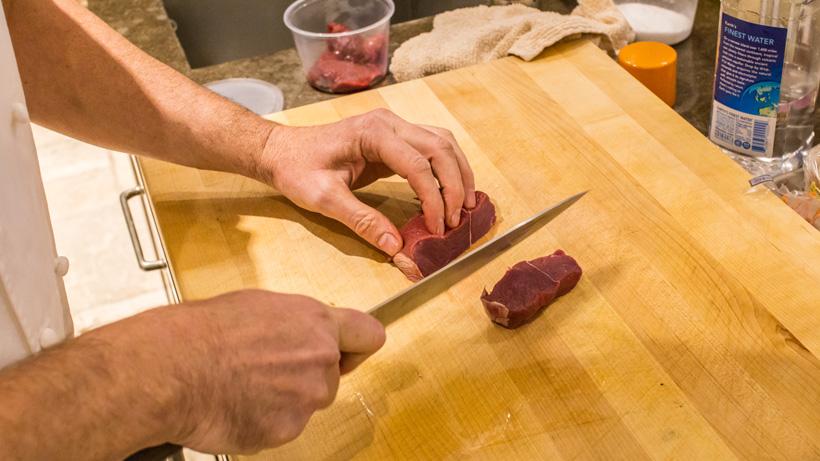 Cutting elk meat into small chunks
